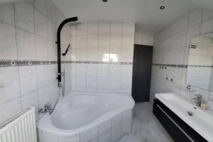 een witte badkamer met een groot bad en een wastafel bij 100 qm DG Wohnung 《Kehr wieder》Bexbach Saarland in Bexbach