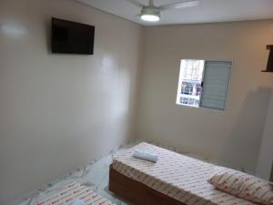 Hotel Avenida Brás في ساو باولو: غرفة بيضاء فيها سرير وتلفزيون