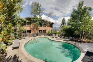 a swimming pool in the backyard of a house at Ski-InandOut Oversized Aspen Studio with Pool and Hot Tub in Snowmass Village