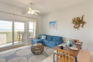 a living room with a blue couch and a table at Oceanfront Galveston Condo in Amazing Location! in Galveston