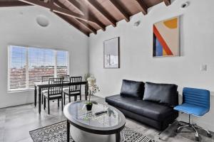 a living room with a black couch and a table at Lovely 1 Bedroom Walking Distance To Ocean - Suite 1 in Hollywood