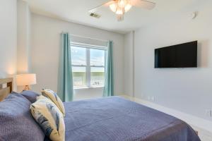 a bedroom with a bed and a tv and a window at Oceanfront Galveston Condo in Amazing Location! in Galveston