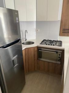a kitchen with a stainless steel stove and a sink at APARTAMENTO TIZIANI MANIZALES in Manizales