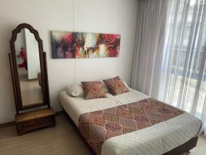 a bedroom with a bed and a mirror at APARTAMENTO TIZIANI MANIZALES in Manizales