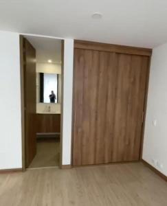 an empty room with a wooden door and a mirror at APARTAMENTO TIZIANI MANIZALES in Manizales