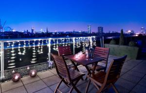 een tafel en stoelen op een balkon met uitzicht bij Park Plaza Victoria London in Londen