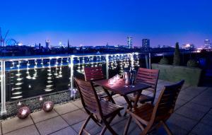 una mesa y sillas en un balcón con vistas en Park Plaza Victoria London, en Londres