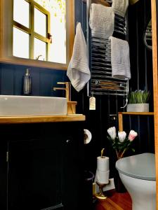 bagno con lavandino bianco e specchio di Church House Hut a Melton Mowbray