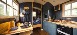 a kitchen with blue cabinets and a sink and window at Church House Hut in Melton Mowbray