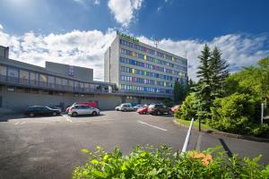 a parking lot with cars parked in front of a building at Hotel Energie in Prague