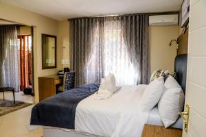 Windhoek Gardens Boutique Hotel tesisinde bir odada yatak veya yataklar