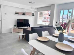 sala de estar con mesa de comedor y TV en Apartamento cerca de la playa, Torre Del Mar, en Torre del Mar