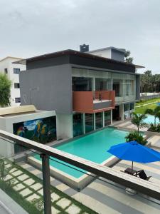 Bijilo的住宿－Aquaview Amina's rental apartment，一座带游泳池和蓝伞的建筑
