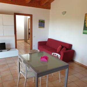 a living room with a red couch and a table at Case Vacanza Villaggio Riva Azzurra in Policoro +12 photos