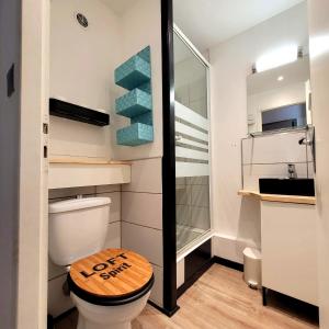 La salle de bains est pourvue de toilettes et d'un siège en bois. dans l'établissement Le REVOL, à Grenoble