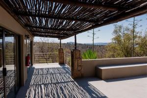 a view from the porch of a house with a pergola at Elements Bush Villa 295 in Mabula
