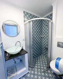 een badkamer met een wastafel, een toilet en een spiegel bij Mercan Otel in Canakkale
