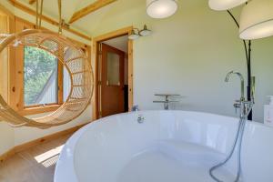 a bathroom with a tub and a round mirror at Catskills Mountain Cabin in Bloomville! in Stamford +32 photos