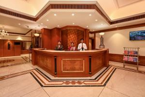 Fariyas Hotel Mumbai , Colaba في مومباي: مجموعة من ثلاثة أشخاص واقفين في بهو الفندق