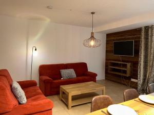 sala de estar con sofá rojo y TV en Appartement Les Gets, 3 pièces, 6 personnes - FR-1-623-328, en Les Gets