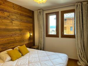 1 dormitorio con 1 cama con pared de madera y ventana en Appartement Les Gets, 3 pièces, 6 personnes - FR-1-623-328, en Les Gets