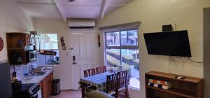 cocina con mesa y TV en la pared en Casa Yorba, en Jacó