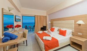 a hotel room with a bed and a view of the ocean at Belair Beach Hotel in Ixia