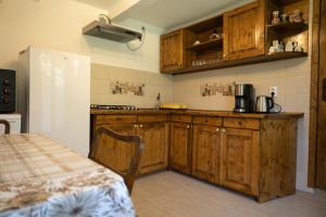 a kitchen with wooden cabinets and a table in it at Casa Adina Sibiel in Sibiel