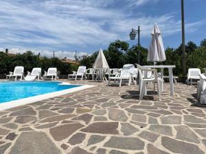 un grupo de sillas y mesas y una piscina en Cottage Ani & Mau en San Massimo