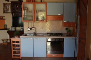 uma cozinha com armários brancos e um forno com placa de fogão em Cottage Ani & Mau em San Massimo