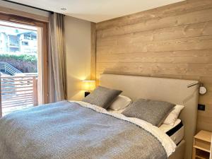 ein Schlafzimmer mit einem Bett mit einer Holzwand in der Unterkunft Appartement Les Gets, 4 pièces, 10 personnes - FR-1-623-342 in Les Gets