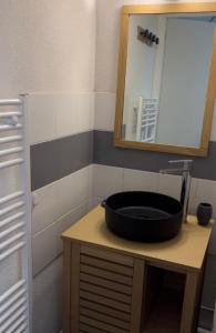 La salle de bains est pourvue d'un lavabo noir et d'un miroir. dans l'établissement Le chalet d'Isis, à Villarodin-Bourget