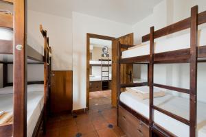 a room with three bunk beds and a mirror at Oasis Backpackers' Hostel Granada in Granada