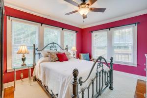 Schlafzimmer mit einem Bett mit roten Wänden und Fenstern in der Unterkunft Quaint Jefferson Duplex Walk to Downtown in Jefferson