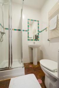 a bathroom with a shower and a toilet and a sink at Oasis Backpackers' Hostel Granada in Granada
