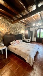 sypialnia z dużym łóżkiem w kamiennej ścianie w obiekcie Centro de Asturias w mieście Collado