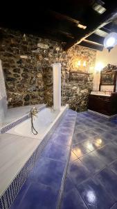 a bathroom with a bath tub in a stone wall at Centro de Asturias in Collado