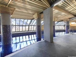 阿沃里亞茲的住宿－Chalet Avoriaz, 5 pièces, 10 personnes - FR-1-314-113，一座建筑,设有一座带柱子和窗户的游泳池