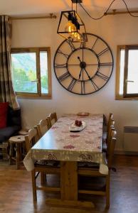 a dining room with a table and a large clock at Le chalet d'Isis in Villarodin-Bourget