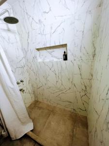 a bathroom with a white marble wall at Departamento Catedral in Santa Rosa