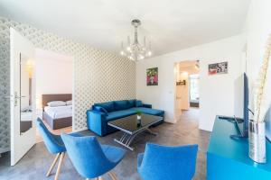 sala de estar con sofá azul y sillas azules en Appartement spacieux 8 pers avec balcon Bron, en Bron