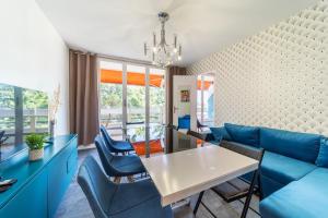 een woonkamer met een blauwe bank en stoelen bij Appartement spacieux 8 pers avec balcon Bron in Bron