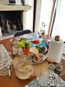 una mesa de madera con platos de comida. en B&B San Nicola en Pretoro