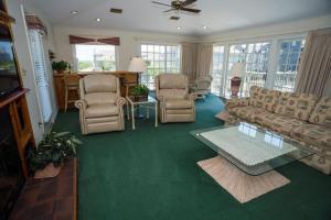 a living room with a couch and chairs and a tv at The Merimoth at Ships Watch in Duck