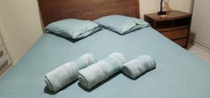 a bed with four pillows on it in a room at Apartamento por temporada RJ próximo ao Riocentro, Parque Olímpico e Jeunesse Arena in Rio de Janeiro
