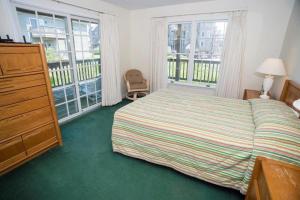 a bedroom with a bed and a dresser and two windows at The Merimoth at Ships Watch in Duck +32 photos