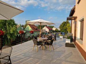 a patio with a table and chairs and an umbrella at Pokoje gościnne Anna in Milicz