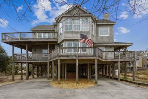 a large house with a balcony and an american flag on it at The Myllet at Ships Watch in Duck