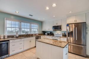 a kitchen with white cabinets and stainless steel appliances at The Myllet at Ships Watch in Duck +26 photos