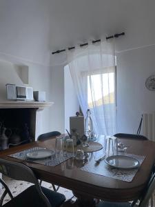 a dining room table with chairs and a table and a window at B&B San Nicola in Pretoro